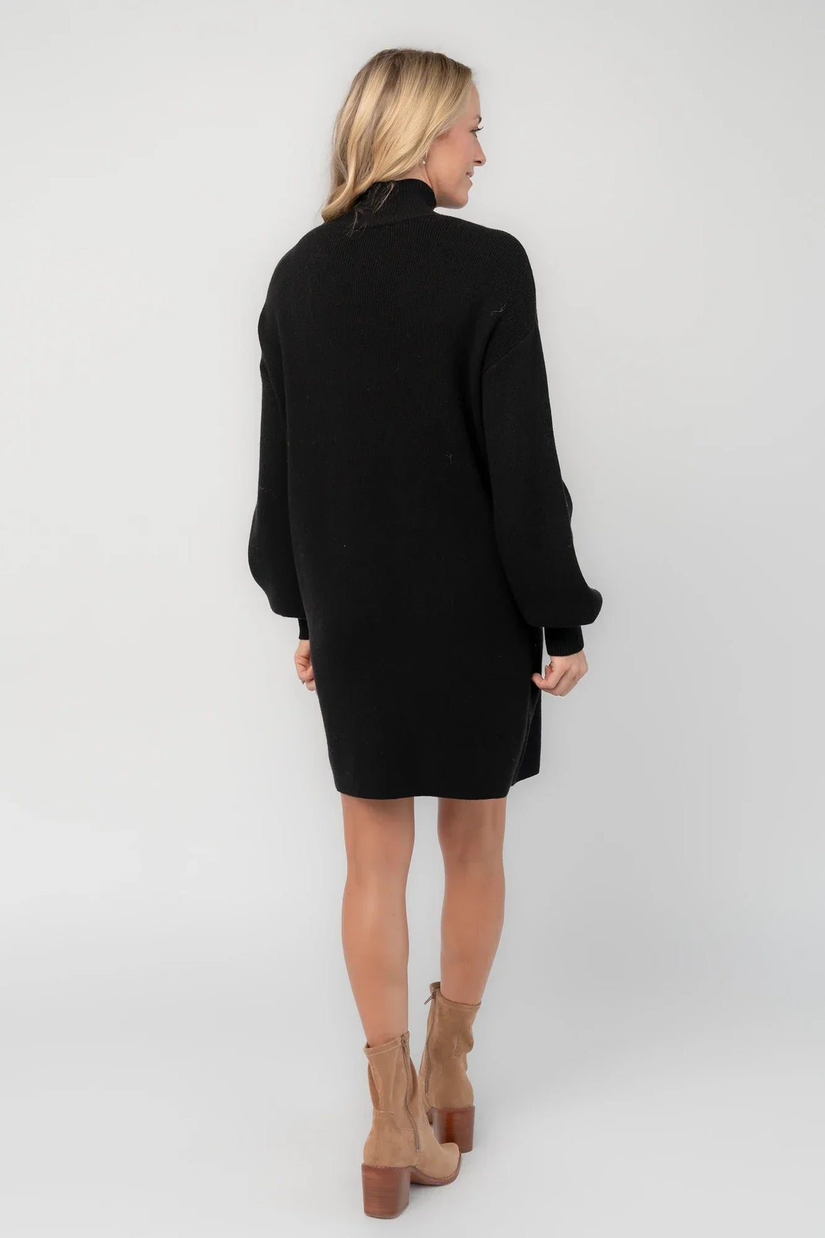Black knit sweater dress with a mock neckline, long balloon sleeves, dropped shoulders, and a relaxed above-the-knee silhouette.