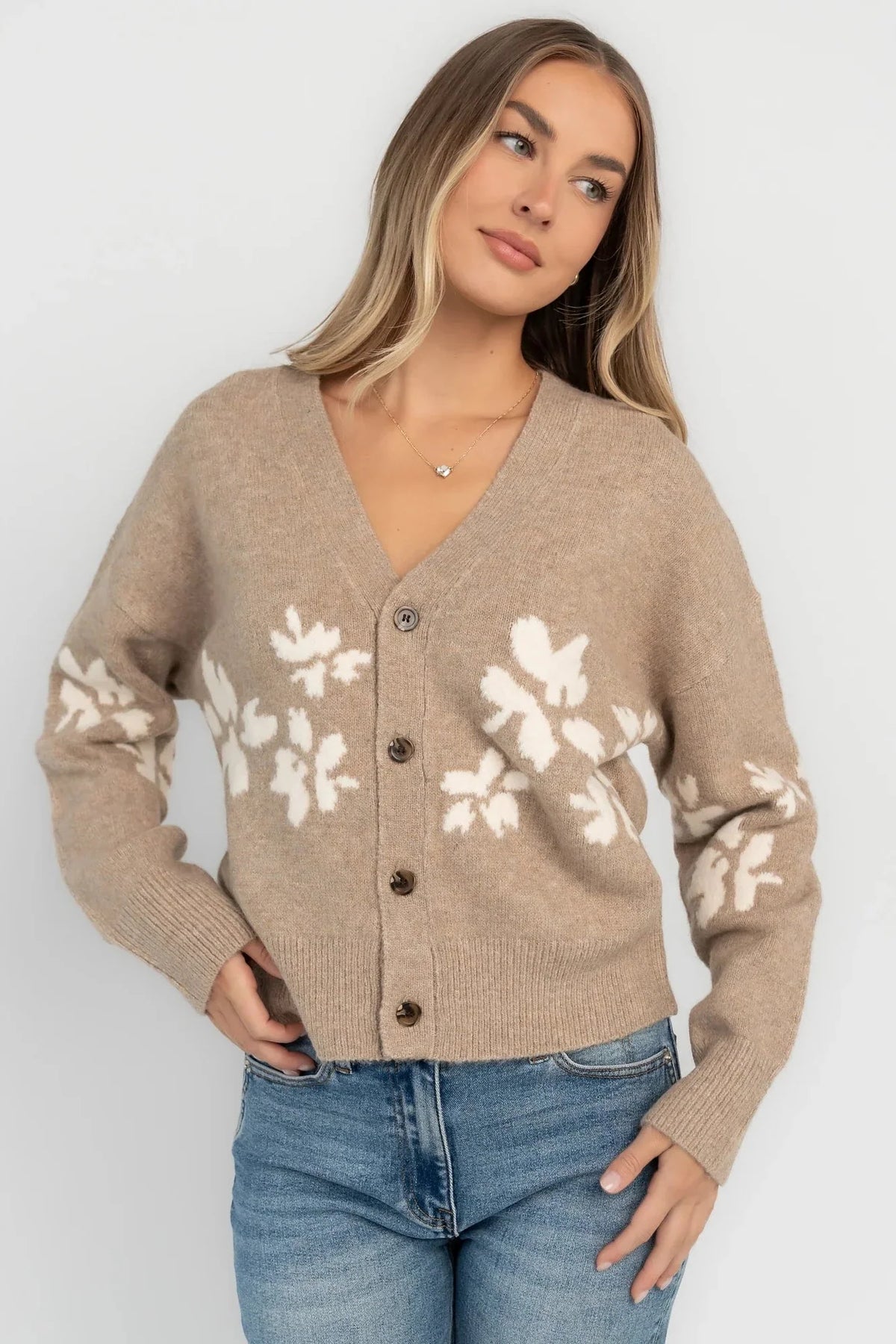 Taupe floral knit cardigan with a V-neckline, button-front closure, long sleeves, ribbed trim, and a relaxed silhouette.